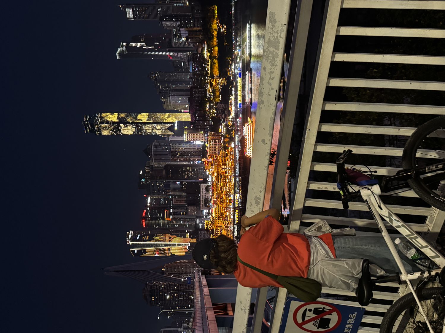 Cyclist overlooking Chongqing’s illuminated skyline